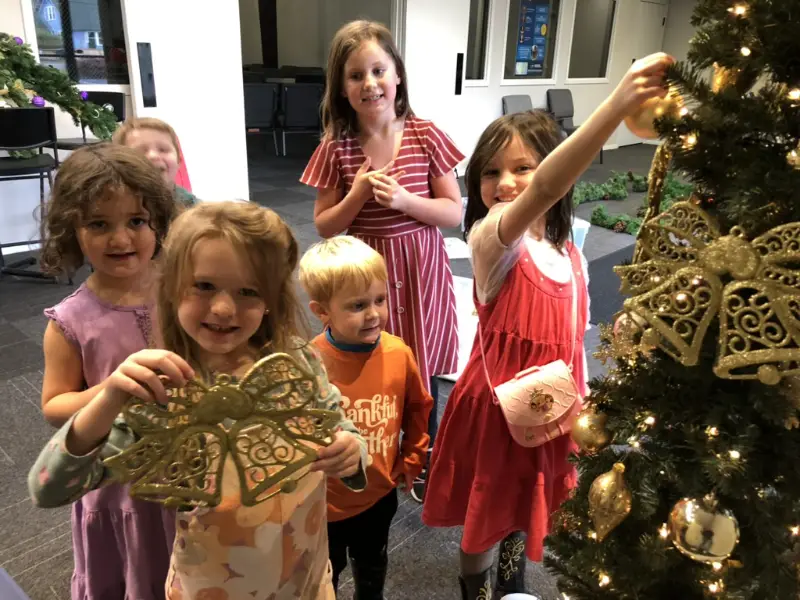 Dids decorating a Christmas tree