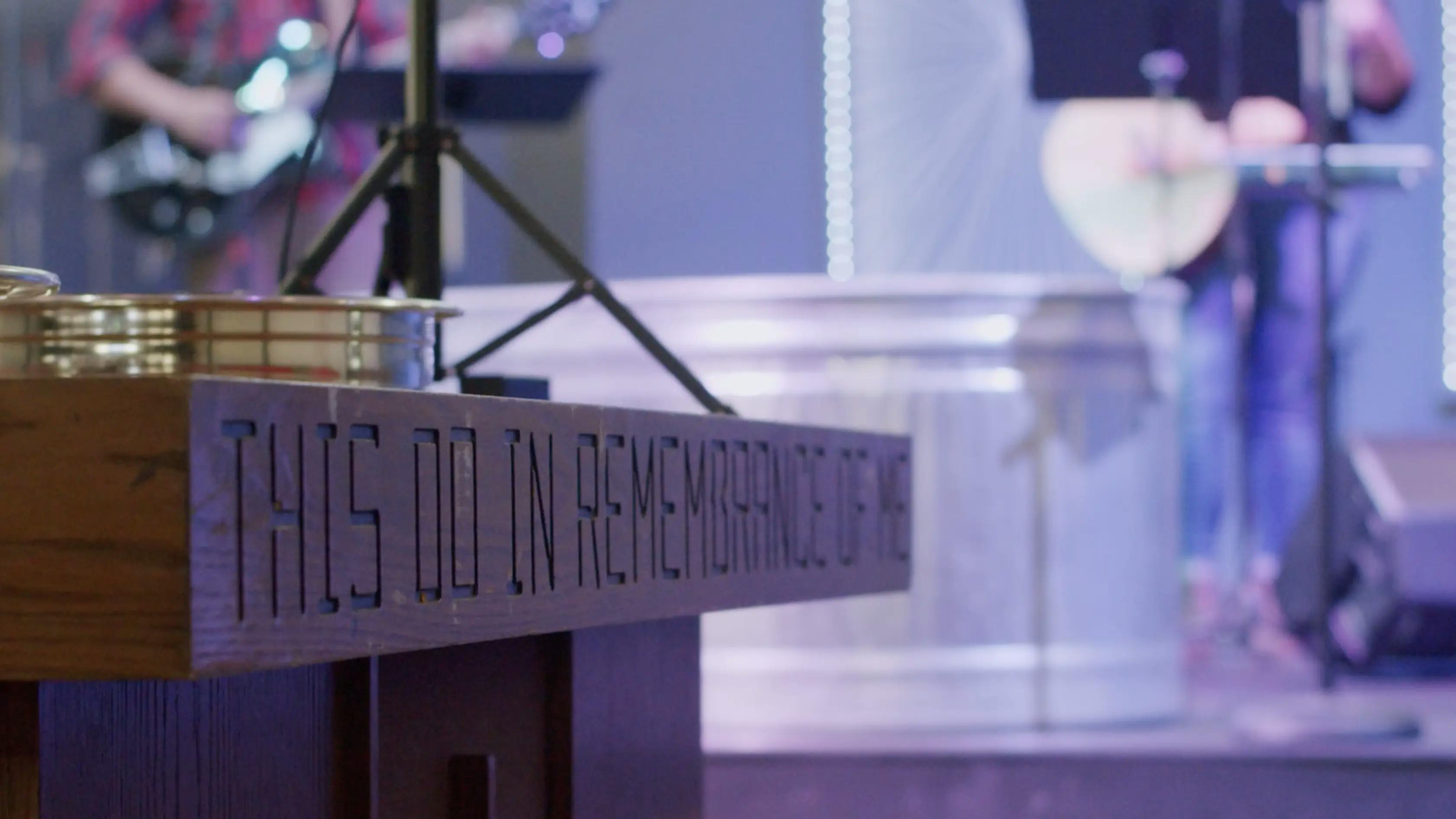 A communion table that reads "Do this in remembrance of me"