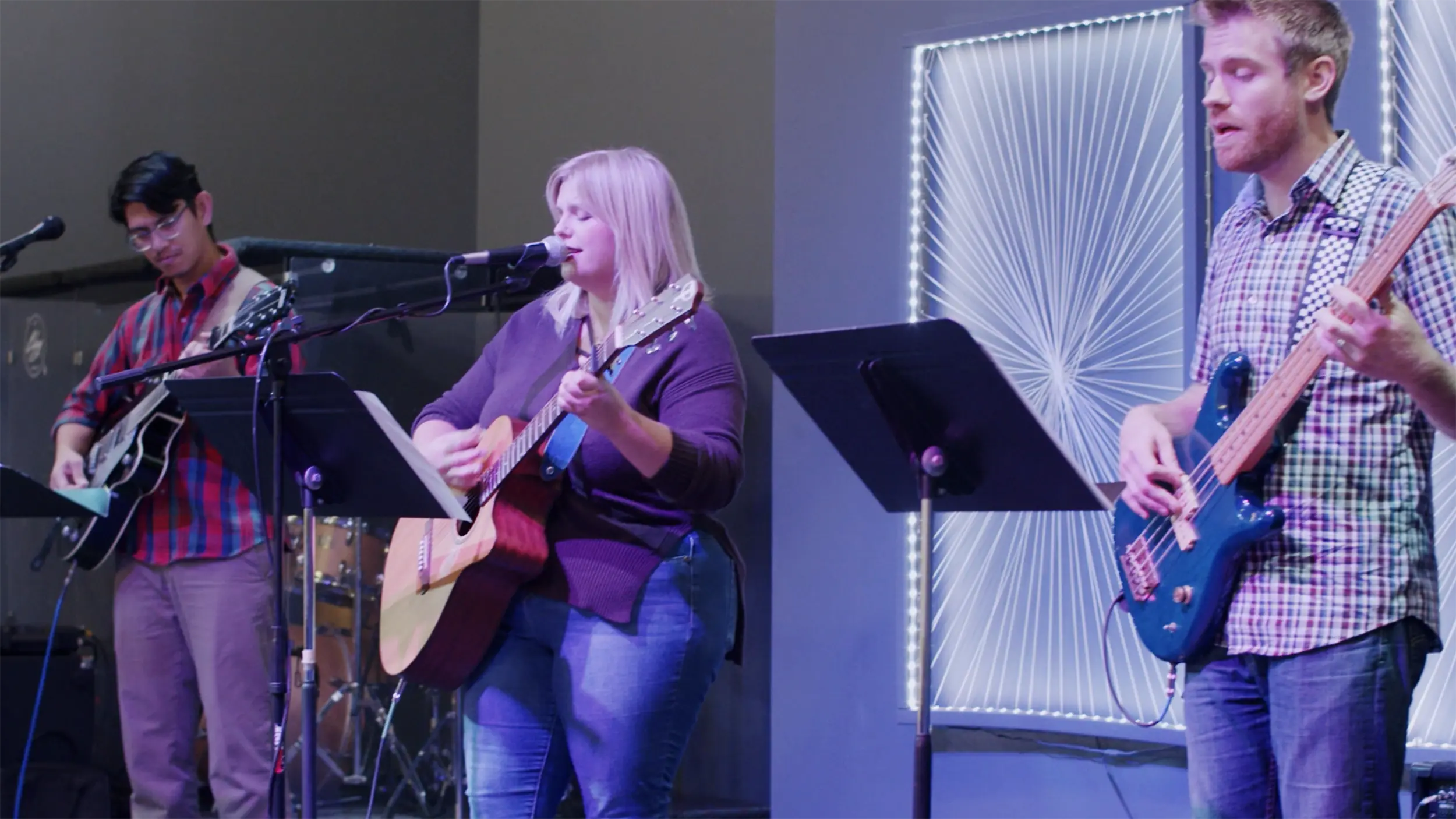 Three guitar players leading worship on a Sunday morning